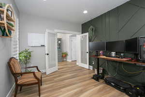 Office with french doors and light hardwood / wood-style floors