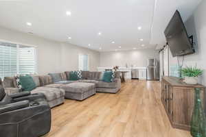 Living room with plenty of natural light, sink, and light hardwood / wood-style floors