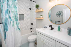 Full bathroom with tile patterned floors, vanity, shower / bathtub combination with curtain, and toilet