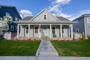 View of front of property featuring covered porch and a front lawn