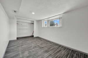 Interior space with a textured ceiling, carpet flooring, and a closet