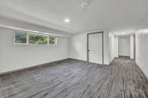 Basement featuring a textured ceiling and carpet floors