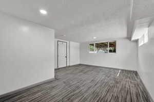 Unfurnished room with a textured ceiling and carpet flooring