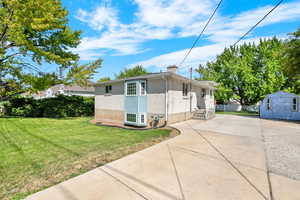 View of front of home with a front yard and a storage unit