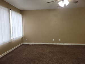 Unfurnished room featuring ceiling fan, carpet, and a healthy amount of sunlight