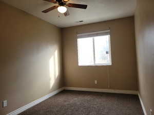 Carpeted spare room featuring ceiling fan