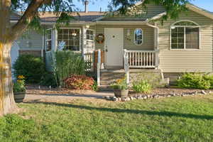 View of front of home with a front yard and covered porch