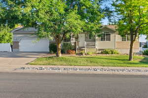 Obstructed view of property featuring a porch, a front yard, and a garage