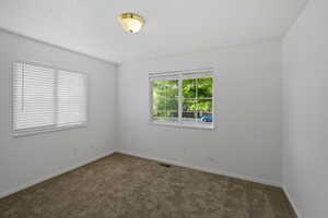 Empty room featuring dark carpet