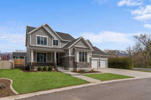 Craftsman inspired home with a porch, a garage, and a front lawn