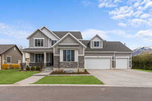 Craftsman inspired home featuring a front yard, covered porch, and a garage