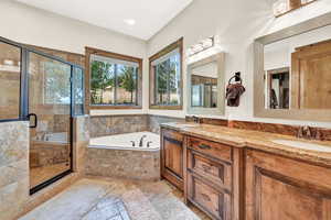 Bathroom featuring independent shower and bath, dual vanity, and tile patterned floors