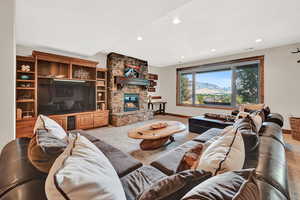 Living room with built in features, a fireplace, and carpet flooring