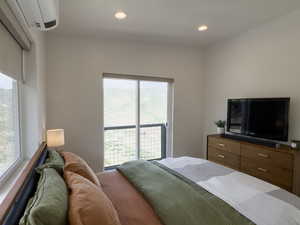 Bedroom featuring a wall mounted air conditioner and access to outside