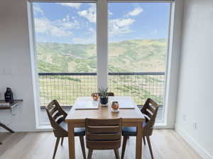 Dining room featuring light hardwood / wood-style flooring, a mountain view, and a wealth of natural light