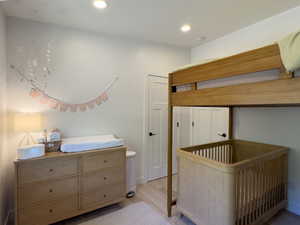 Bedroom featuring light hardwood / wood-style flooring and a crib