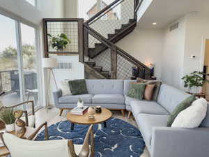 Living room with light wood-type flooring and a high ceiling