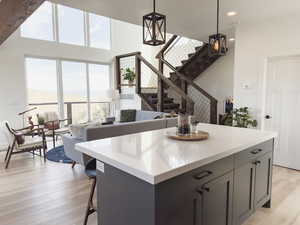 Kitchen featuring light wood-type flooring, gray cabinets, pendant lighting, and a healthy amount of sunlight