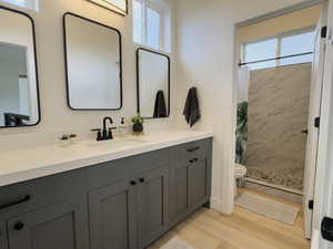 Bathroom featuring toilet, vanity, a shower with shower curtain, and hardwood / wood-style floors