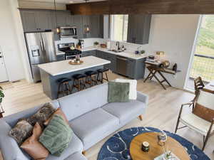 Kitchen featuring a kitchen island, gray cabinets, light hardwood / wood-style floors, stainless steel appliances, and sink