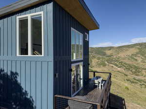 View of side of property with a deck with mountain view