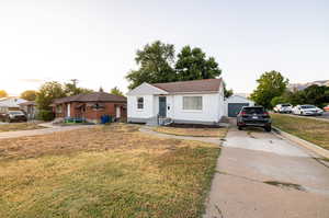 View of front of property with an outdoor structure, a garage, and a front yard