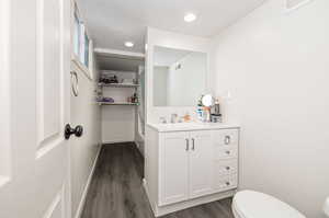 Bathroom with wood-type flooring, toilet, and vanity