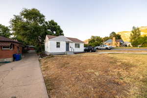 View of front of house with a mountain view and a front lawn