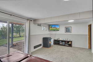 Interior space with a wood stove, a textured ceiling, and carpet flooring