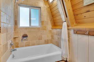 Bathroom with wooden ceiling, shower / tub combo with curtain, and lofted ceiling