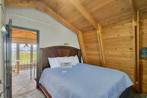 Bedroom featuring carpet floors, wood ceiling, and lofted ceiling with beams