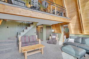 Living room featuring carpet, wood ceiling, and wooden walls