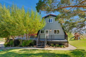 View of front of home featuring a playground, a deck, and a front yard