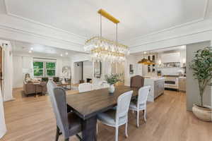 Dining space featuring light wood-type flooring and ornamental molding