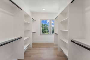 Walk in closet with light wood-type flooring