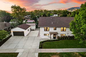 View of front facade featuring a garage, an outdoor structure, and a lawn