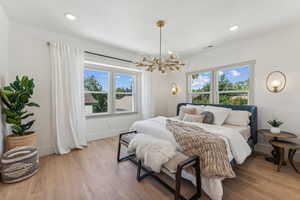 Bedroom with light wood-type flooring and a chandelier