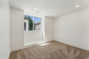 Unfurnished room with a textured ceiling and carpet