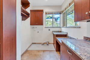 Laundry room with hookup for an electric dryer, cabinets, plenty of natural light, and washer hookup