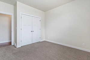 Unfurnished bedroom with a closet and carpet