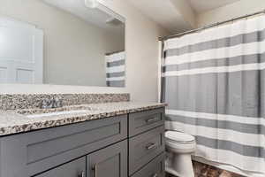 Bathroom with hardwood / wood-style flooring, vanity, and toilet