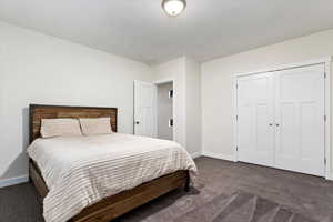 Carpeted bedroom with a closet