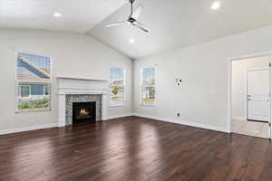 Unfurnished living room with ceiling fan, lofted ceiling, and hardwood / wood-style floors