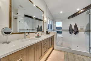 Bathroom with tile patterned flooring, double sink vanity, and an enclosed shower