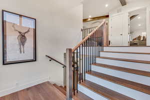 Stairs featuring lofted ceiling with beams and hardwood / wood-style flooring