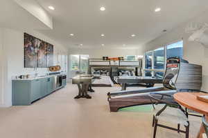 Gym with sink and light colored carpet