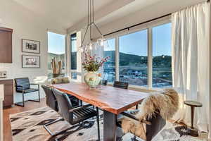 Dining room with plenty of natural light, lofted ceiling, and light wood-type flooring