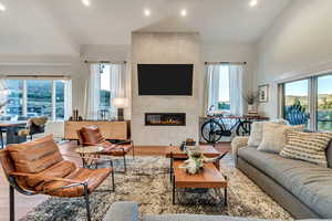 Living room with hardwood / wood-style floors, a tiled fireplace, and tile walls