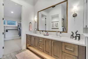 Bathroom with dual bowl vanity and tile patterned floors