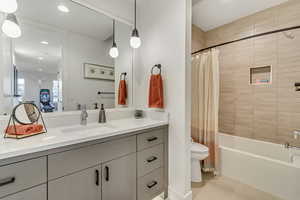 Full bathroom featuring tile patterned floors, vanity, shower / tub combo with curtain, and toilet